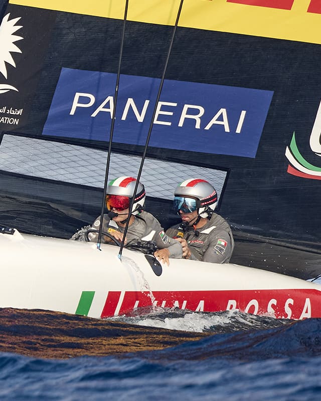 The young helmsman Marco Gradoni skillfully steers the Luna Rossa alongside the second helmsman.